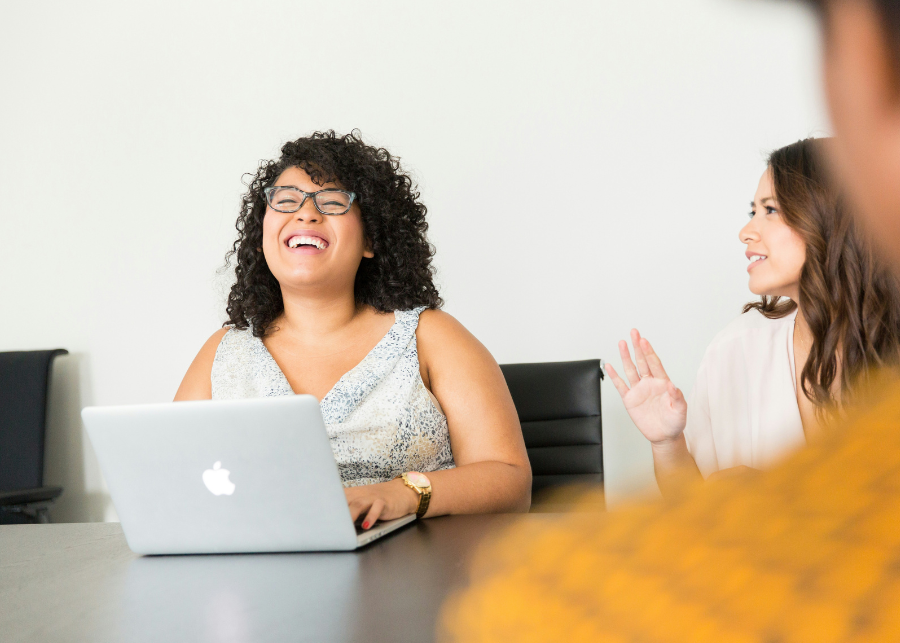 Women sitting at table in front of conputer